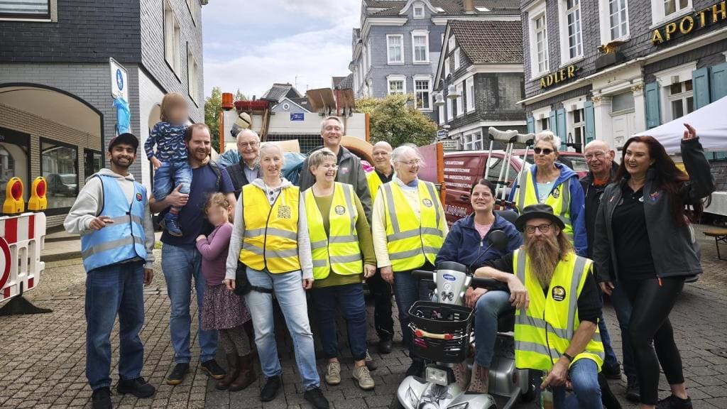 Gruppenfoto von rund 20 Helferinnen und Helfern, viele in gelben Warnwesten in der Schwelmer Altstadt