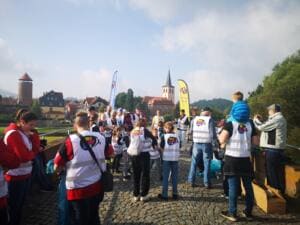 Viele Menschen in Warnwesten stehen auf der Brücke, im Hintergrund der Burgturm, der Kirchturm und Beachflags.